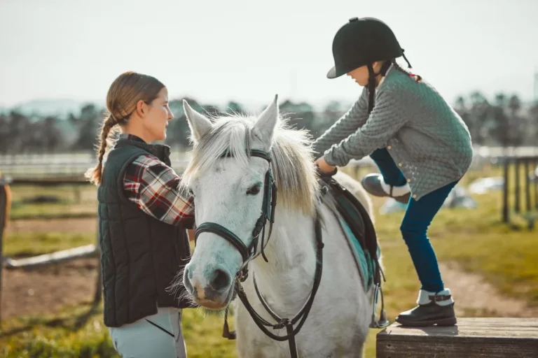 Child learning horseback riding with instructor
