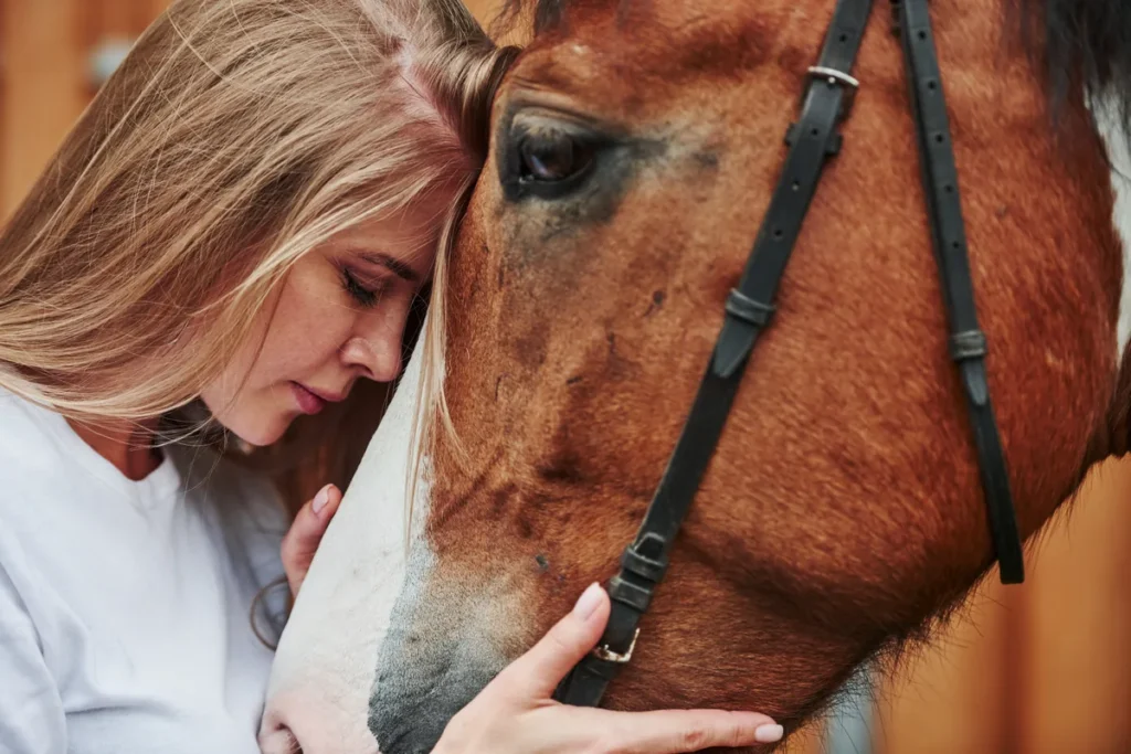 Woman sharing a close moment face to face with her horse on the ranch