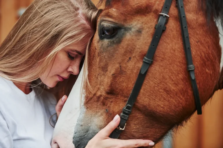 Woman sharing a close moment face to face with her horse on the ranch
